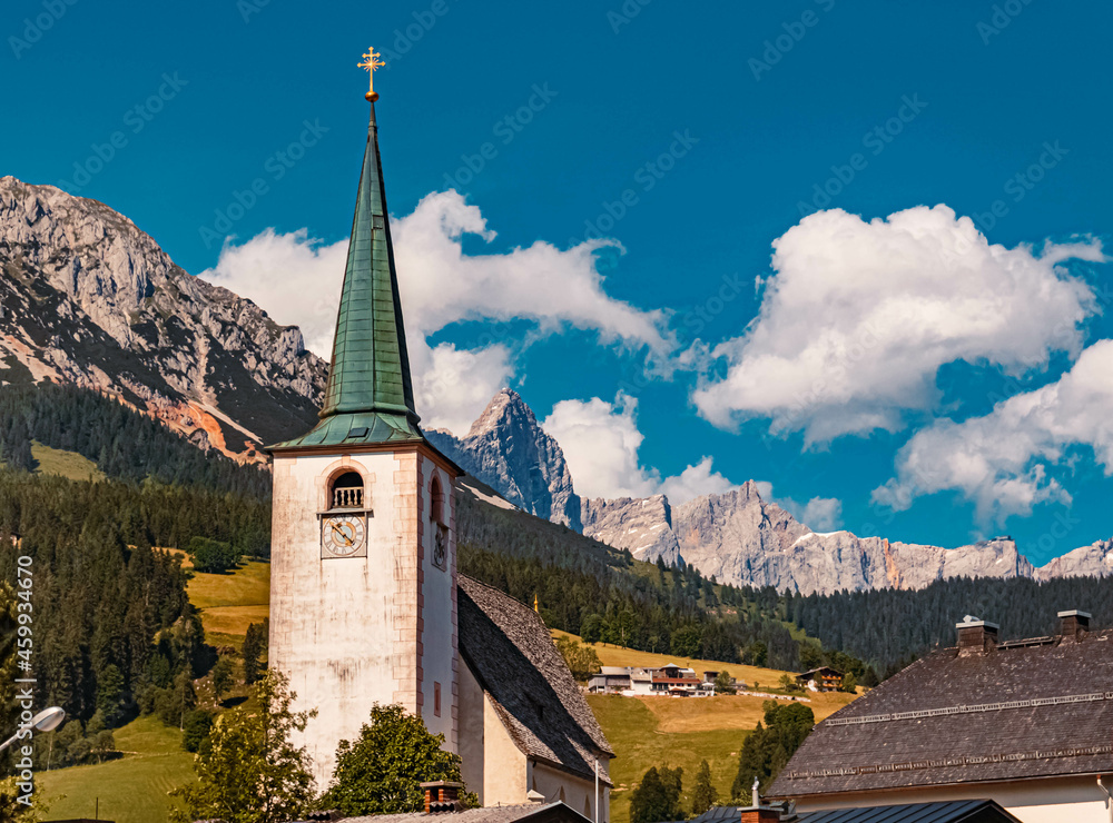 Beautiful church with the famous Dachstein summit in the background at Filzmoos, Salzburg, Austria on a sunny summer day
