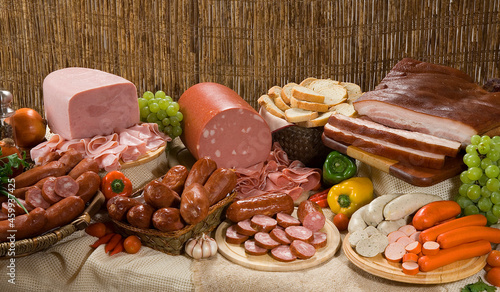 Composição com produtos embutidos, linguiça, bacon, presunto, salsichas em mesa rústica.