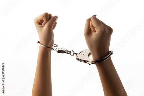 Handcuffed female hands on white background.