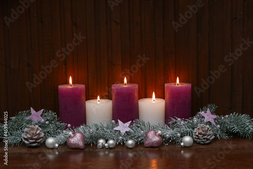  Weihnachtsdekoration mit Kerzen und vor Holzhintergrund.