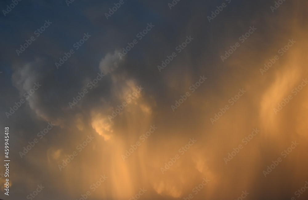 rain falling down from a cumulonimbus cloud with brigth sunligth