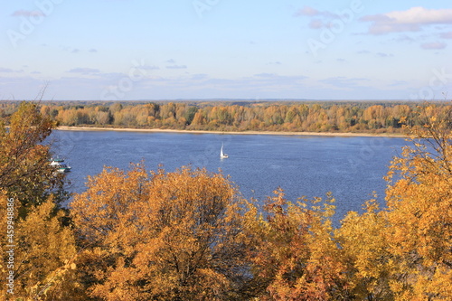 the banks of the river are golden because of the autumn color of the foliage