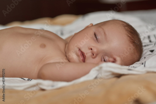 Restful baby peacefully sleeping in soft and cosy bed
