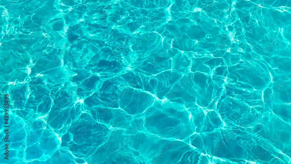 Water surface texture, Slow motion clean swimming pool ripples and wave, Refraction of sunlight top view texture sea side white sand, sun shine water background. Water Caustic Background.