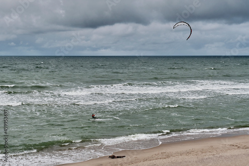 Beautiful seascape with kitesurfer, riding waves.