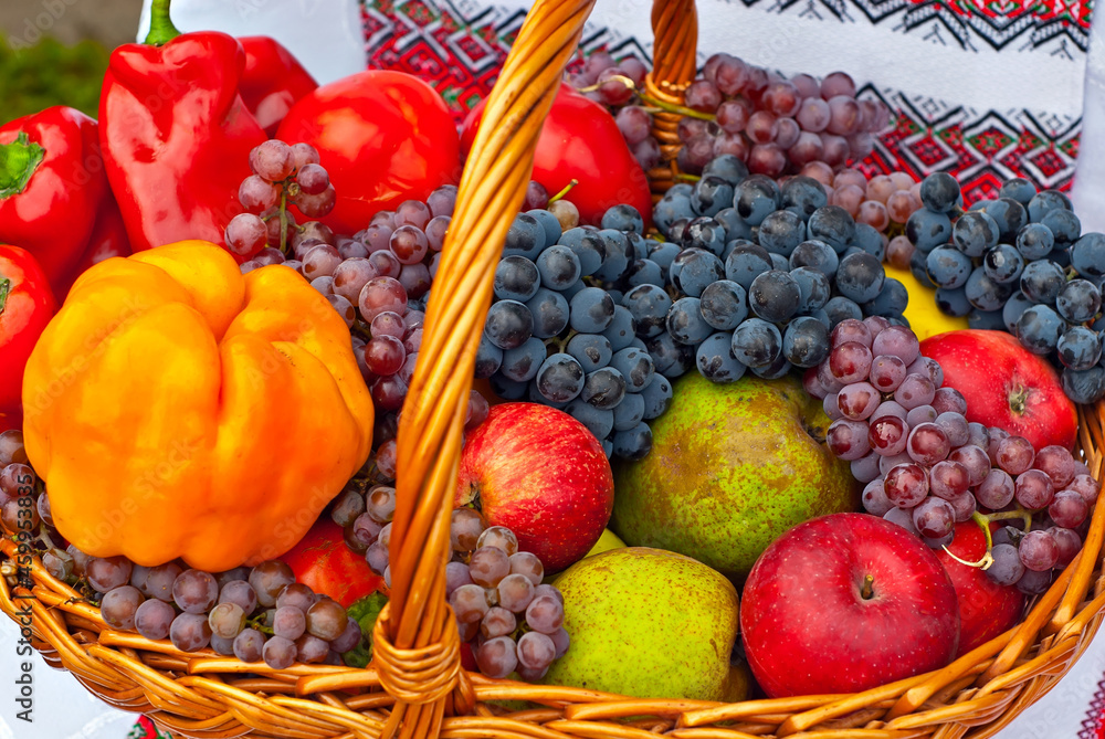 Apples, pears, grapes and peppers in a basket. Vegetables close up. Picnic food. Apples, pears, grapes and peppers in a basket. Vegetables close up. Picnic food.