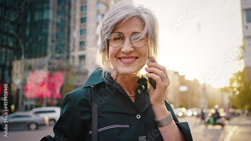Close up portrait of a lovely modern woman in the middle of a city street. Happy mature lady, business woman, equal rights and feminism concept. Slow motion