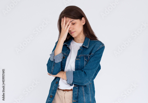 Embarrassed annoyed adult woman hiding face bend head down, facepalm, smirk irritated, not looking friend acting weird, feel humiliated uncomfortable, standing white background