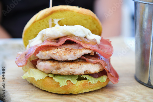 Chicken burger with bacon, lettuce, tomato and mayo.