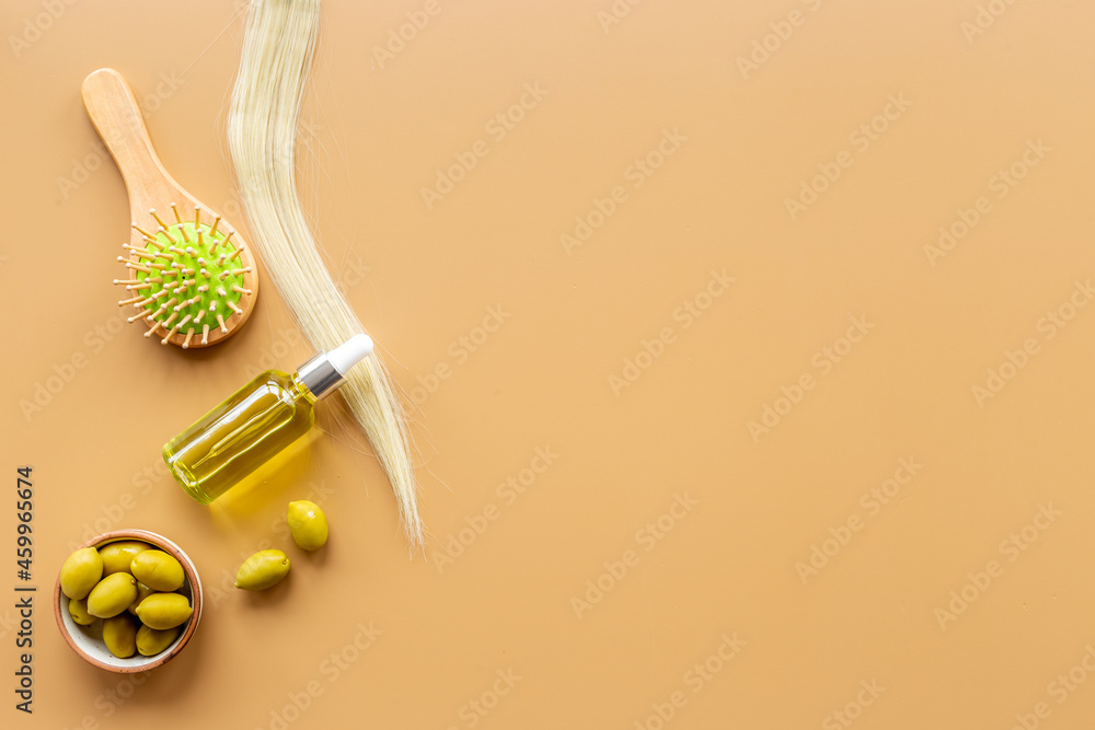Olive oil for hair treatment with wooden hair brush