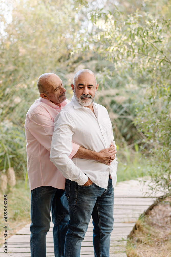 Affectionate gay couple enjoy time together during an outdoor date in nature. LGBT community, equal rights and tolerance concept. Affectionate gay couple enjoy time together during an outdoor date in nature. LGBT community, equal rights and tolerance concept.