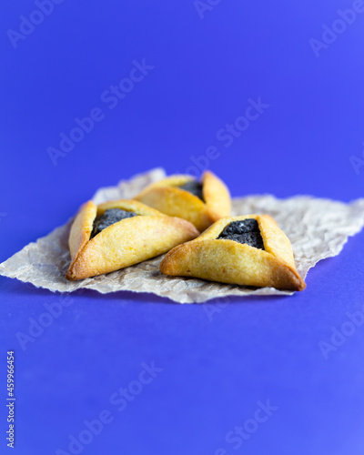 Traditional Jewish triangular hamantaschen cookies with poppy filling. Purim celebration concept. . photo