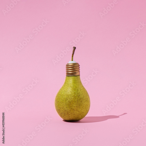 Creative composition of pear light bulb on pastel pink background. Innovation, idea and creativity concept. Minimal aesthetic design.