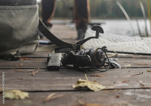 Autumn fishing concept. Reel on wood jetty.