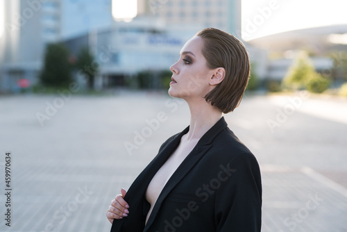 Stylish and attractive Caucasian girl in a suit posing on the street. Fashionable lady. Fashion concept