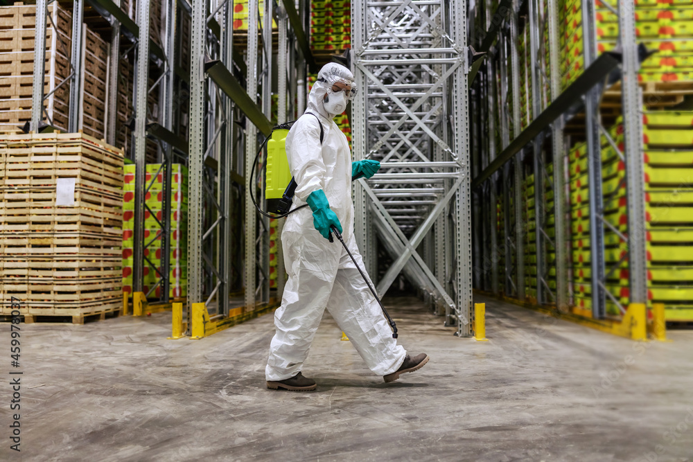 A professional person in protective clothing is determined to defeating the coronavirus in the high-risk area in the warehouse. Disinfection of shelf space. Prevention COVID19, pandemic situation A professional person in protective clothing is determined to defeating the coronavirus in the high-risk area in the warehouse. Disinfection of shelf space. Prevention COVID19, pandemic situation
