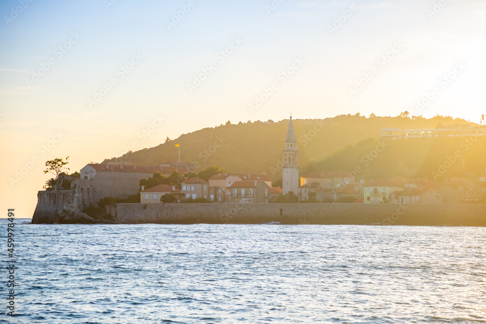 View from water of the old town of Budva city in Montenegro, view from island of St. Nicholas at sunset time