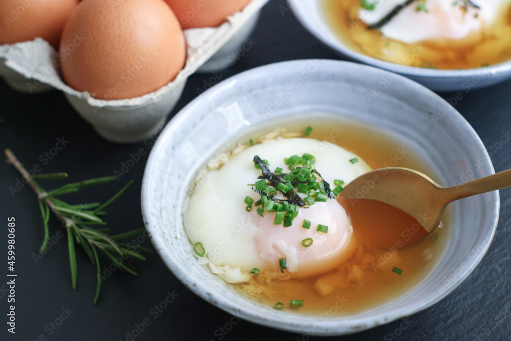 Close up of traditional Japanese hot spring egg (Onsen Tamago) in a bowl with spoon to eating, it's a traditional method of boiling eggs in the hot springs of Japan Close up of traditional Japanese hot spring egg (Onsen Tamago) in a bowl with spoon to eating, it's a traditional method of boiling eggs in the hot springs of Japan