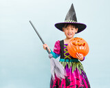 young girl with witch halloween costumes against blue background