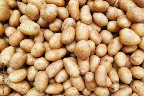 Large pile of potatoes on market counter. Food background and potatoes harvest concept. photo