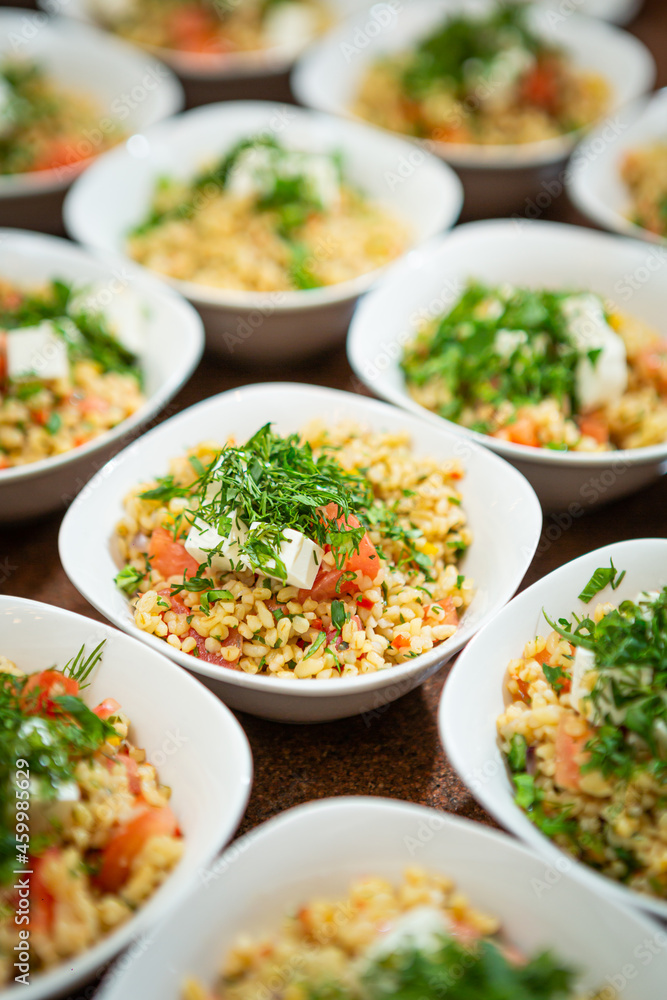 plates of vegetarian food are in a row on the table, spelled with tomatoes and herbs plates of vegetarian food are in a row on the table, spelled with tomatoes and herbs