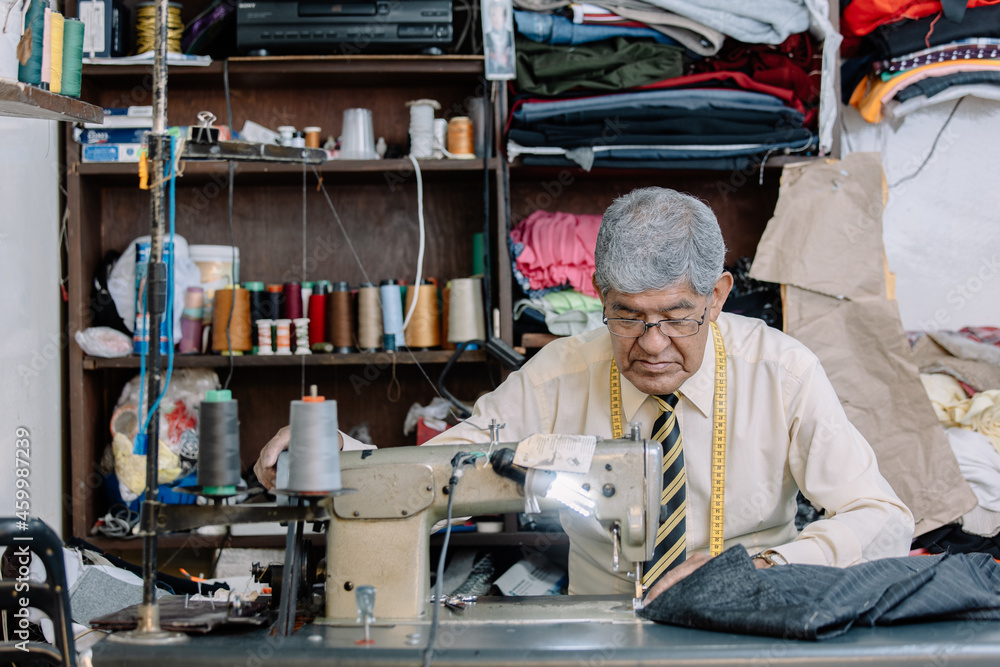 Portrait of an old Mexican tailor working with sewing machine Portrait of an old Mexican tailor working with sewing machine