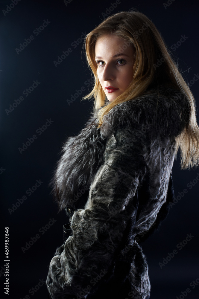 Young attractive woman in fur coat over black Young attractive woman in fur coat over black