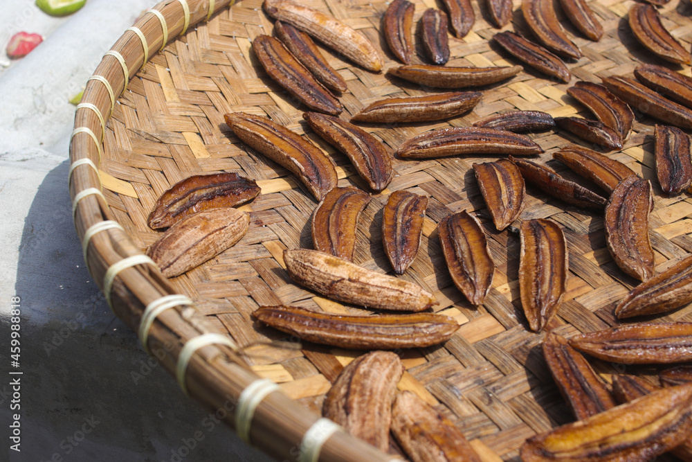 Sale pisang is an Indonesian traditional banana snack that is sliced and laid out in the sun to dry. A group of dried sliced bananas on a container called 