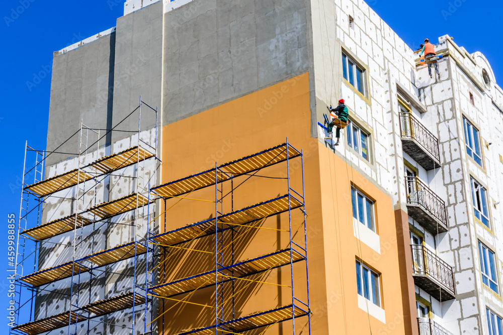 Insulation of the multistory residential building with styrofoam. Rope ...