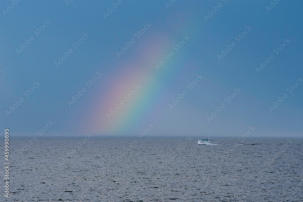 Canadian East Coast lobster fishing boat with rainbow in background.