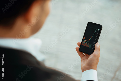 Fotografie A trader trades on the stock exchange in his phone