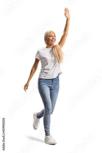 Full length shot of a young casual woman running and waving with hand