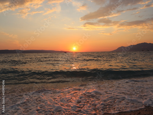 Sunset at the beach. Sunset on the seashore  the setting sun is reflected on the wet sand and on the surface of the water