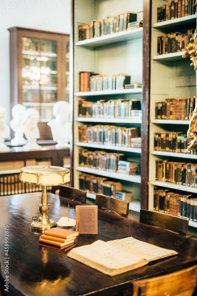 interior of an old house cabinet with books, wooden furniture and lamp interior of an old house cabinet with books, wooden furniture and lamp