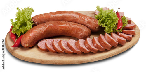 Linguiça calabresa inteira e fatiada em tábua de madeira no fundo branco para recorte.