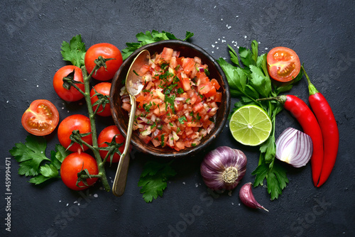 Tomato salsa (salsa roja) - traditional mexican sauce with ingredients for making .Top view with copy space.