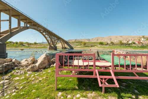 Metallic structure with mats and cushions to have a relaxing time on the banks of the Tigris river and in the shadow of a bridge with two arches