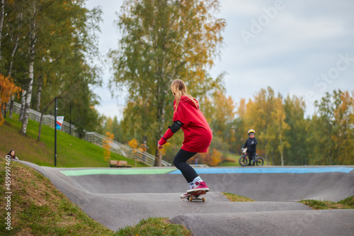 young girl rides in a skate park in clear weather. park for extreme sports.