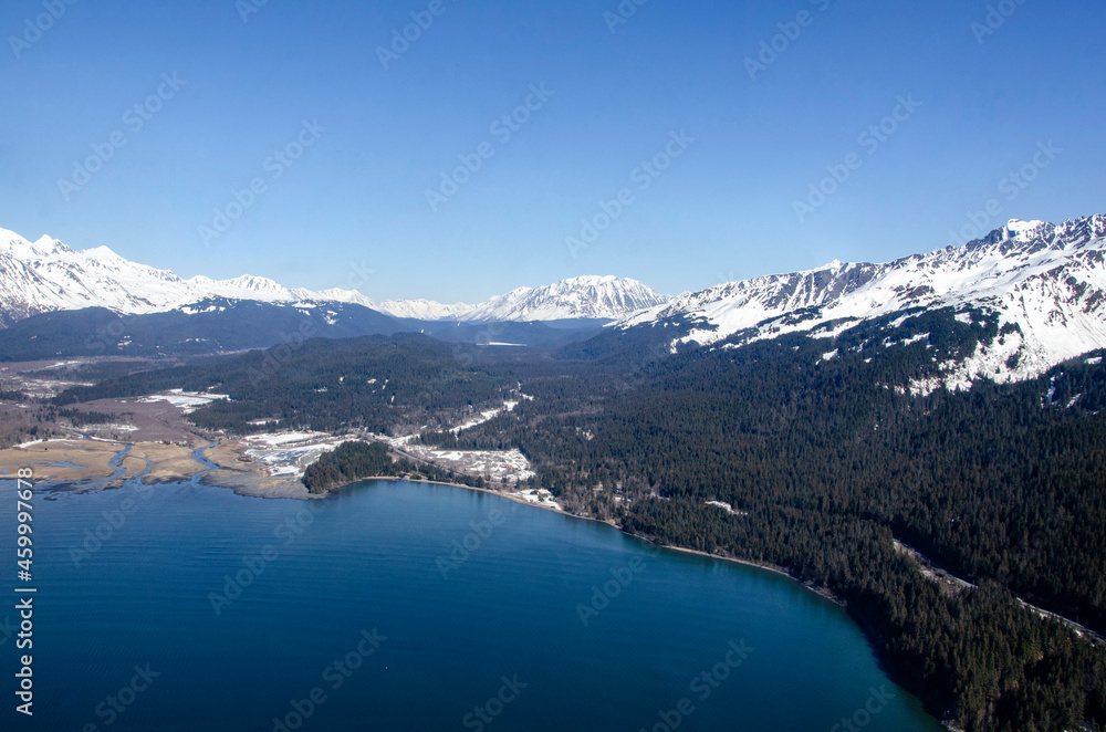 Snow covered mountains by the ocean shoreline