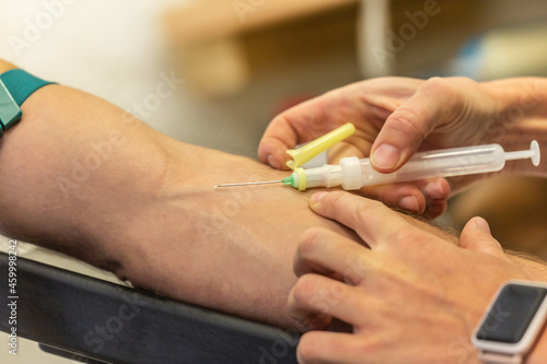 A nurse preparing an intravenous injection for taking a blood sample at a patient  s arm