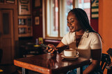 African american woman using smartphone while in a cafe