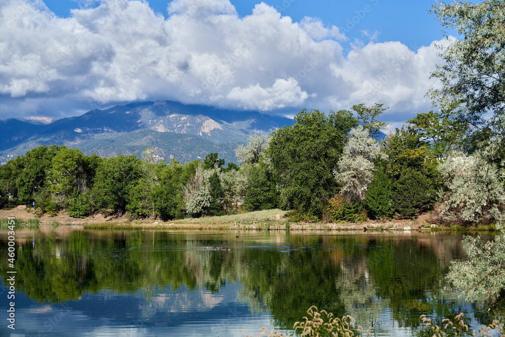 Scenic View of Colorado Springs Lake with reflection of Trees, Mountain and Clouds in Lake Scenic View of Colorado Springs Lake with reflection of Trees, Mountain and Clouds in Lake