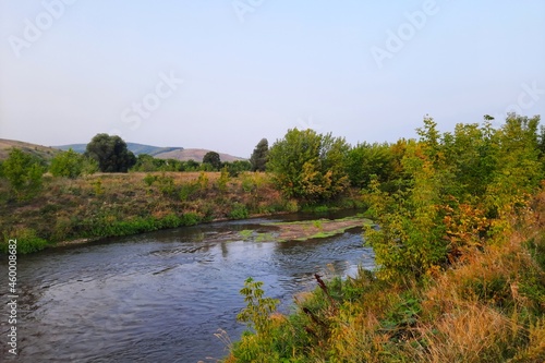 Steppe river against the background of a beautiful blue sky and green vegetation