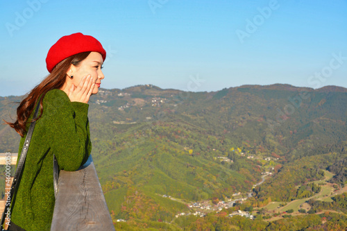 秋の紅葉の風景を眺める女性