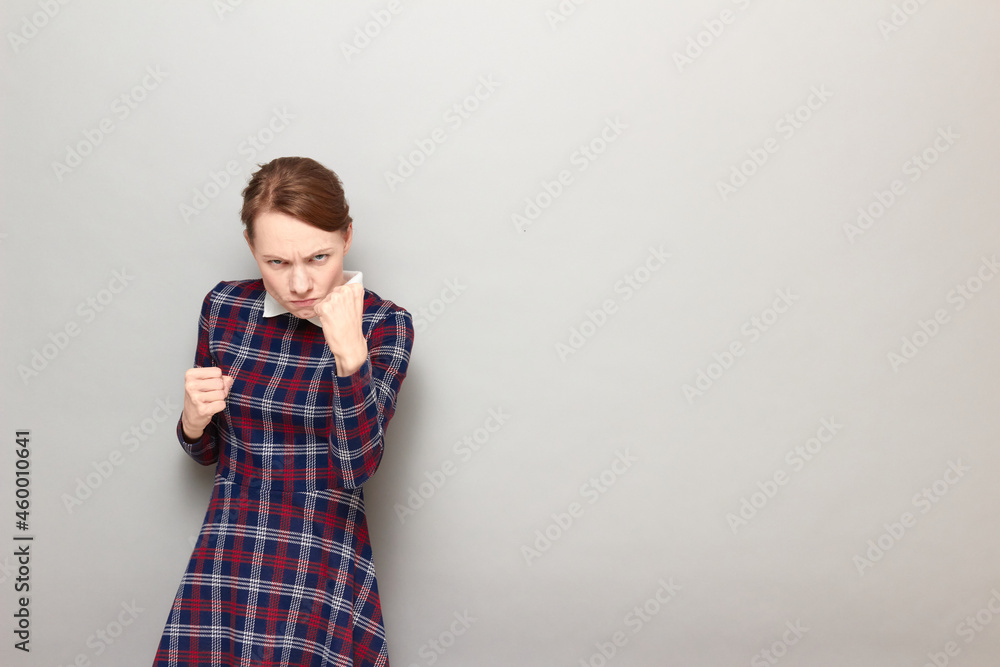 Portrait of angry furious girl raising fist up in threatening gesture Portrait of angry furious girl raising fist up in threatening gesture