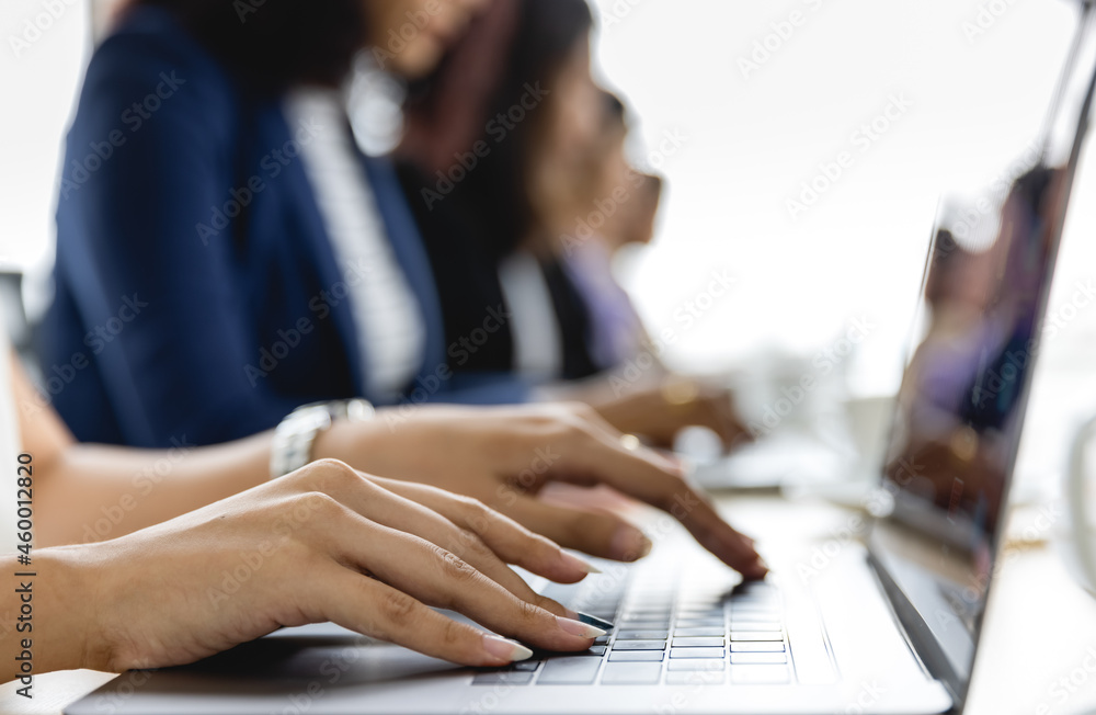 Selective focus on business woman's hands sitting and working on laptop on conference table in office. Concept for business meeting Selective focus on business woman's hands sitting and working on laptop on conference table in office. Concept for business meeting