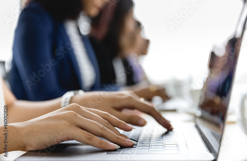 Selective focus on business woman's hands sitting and working on laptop on conference table in office. Concept for business meeting