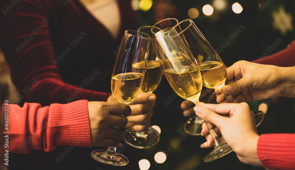 Beverage glasses clinking moment by cheerful woman friends on sweater as enjoy celebrating happy relationship at delightful event of Chirstmas night party