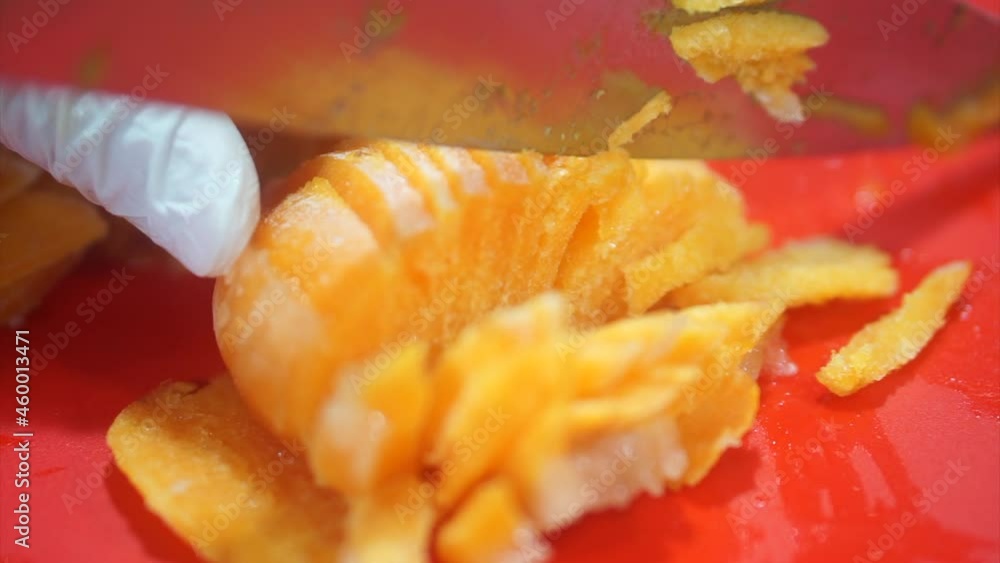 Hand using a kitchen knife to cut Ice Persimmons on a red cutting board. healthy eating. Thinly sliced Ice Persimmons. Hand using a kitchen knife to cut Ice Persimmons on a red cutting board. healthy eating. Thinly sliced Ice Persimmons.