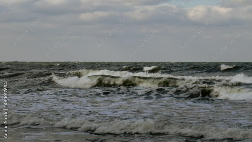 Close-up of stormy foaming waves churned up by the changing tide and whipped by icy wind Close-up of stormy foaming waves churned up by the changing tide and whipped by icy wind